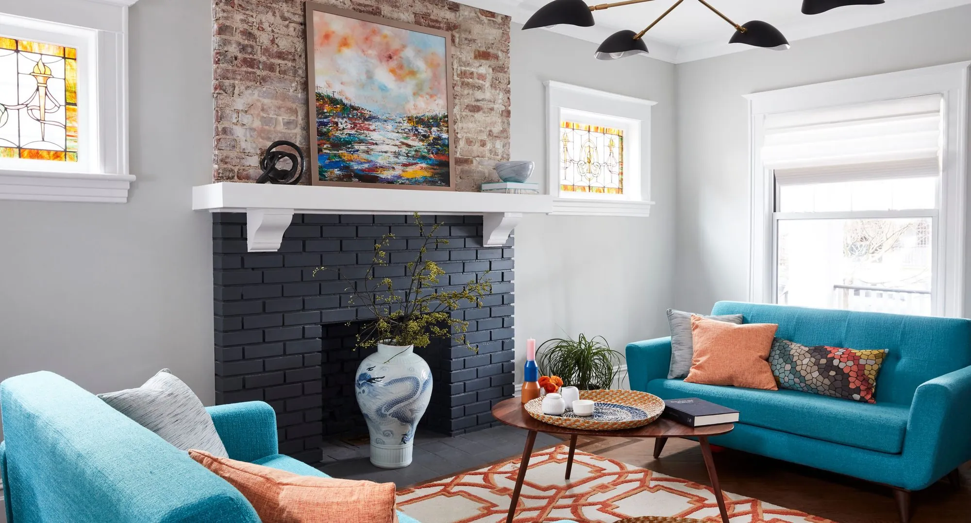 Colorful, tailored living room by Keita Turner Design, a Ditmas Park, Brooklyn interior with teal velvet sofas, exposed brick, and stained glass